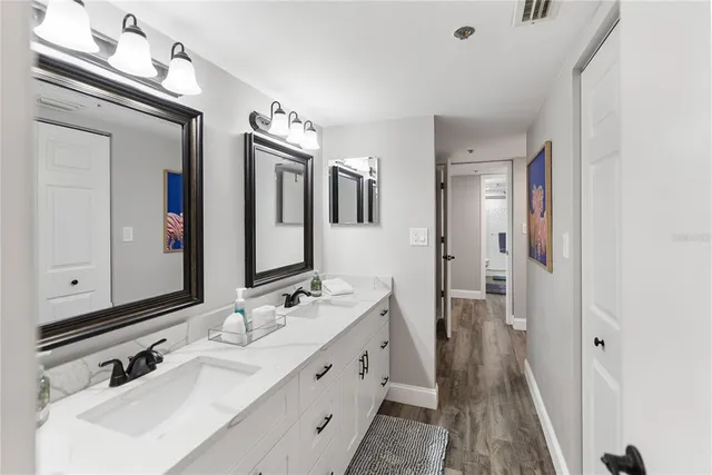 a bathroom with double vanity sink and a mirror