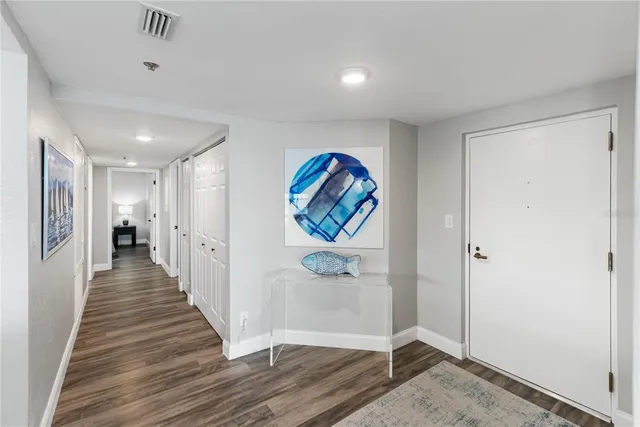 a view of a hallway with wooden floor and entryway