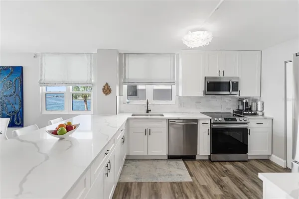 a kitchen with stainless steel appliances a refrigerator sink and stove