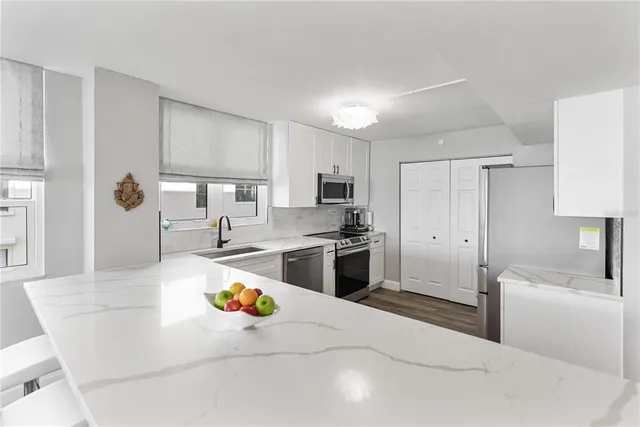 a kitchen with stainless steel appliances a refrigerator sink and stove