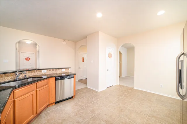 a view of a kitchen with stainless steel appliances granite countertop a sink and cabinets