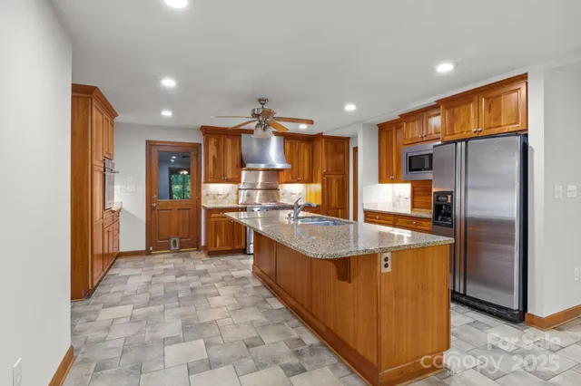 a kitchen with stainless steel appliances granite countertop a refrigerator and a sink