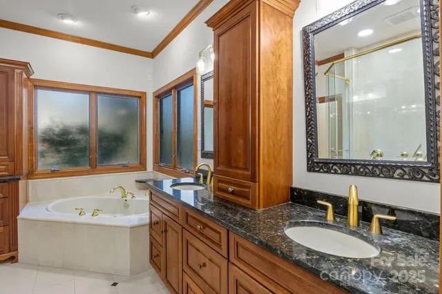 a bathroom with a granite countertop tub sink and mirror