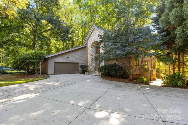 a view of a house with a yard and large trees