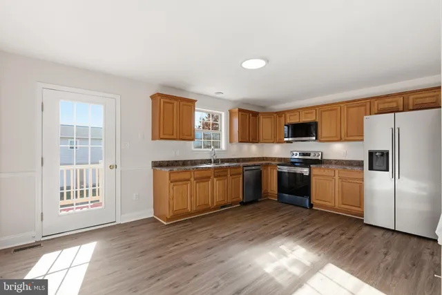 a kitchen with stainless steel appliances granite countertop a refrigerator sink and cabinets