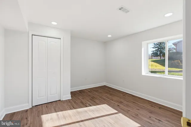 an empty room with wooden floor and window