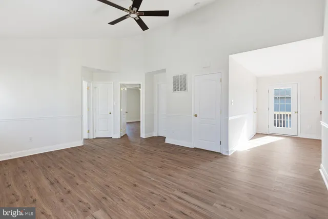 a view of a livingroom with wooden floor and a ceiling fan