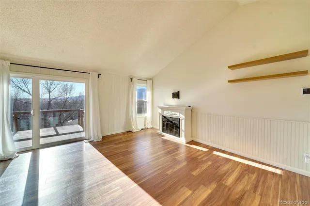 a view of empty room with wooden floor and fireplace