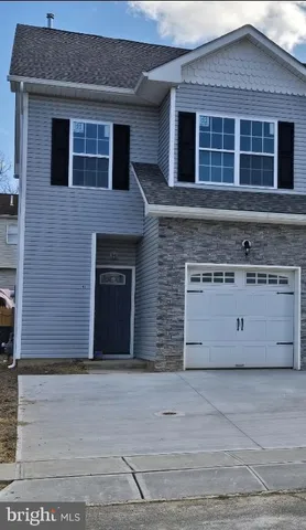 a view of a brick house with a large parking space