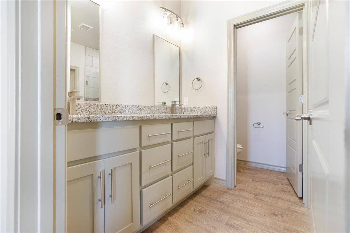 5846 Harvard Street Lubbock, TX 79416 - Photo 12 of 24 a bathroom with a granite countertop sink and a mirror