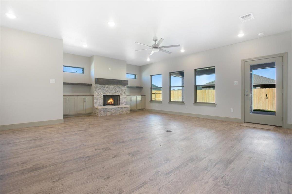 5846 Harvard Street Lubbock, TX 79416 - Photo 2 of 24 an empty room with fireplace and windows