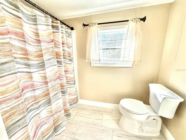 a white toilet sitting next to a shower curtain