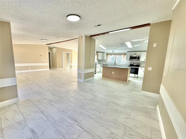 a view of a big room with wooden floor and windows