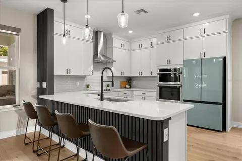 a kitchen with stainless steel appliances a sink a stove a refrigerator and cabinets