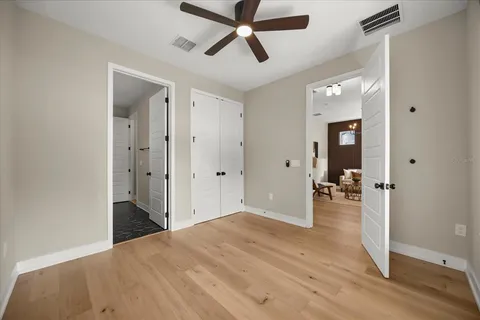 a view of a livingroom with a ceiling fan & entryway