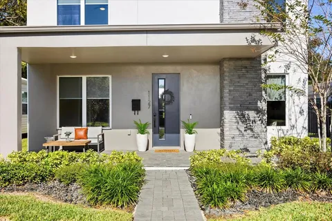 a front view of a house with lots of potted plants