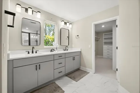 a spacious bathroom with a double vanity sink and mirror