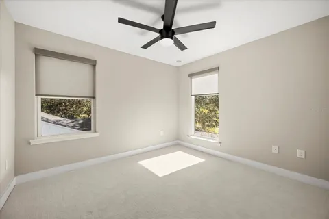 an empty room with a window and a ceiling fan