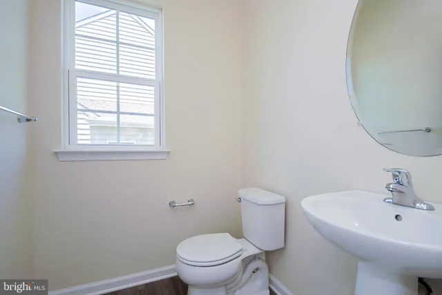 a bathroom with a sink a toilet and a window