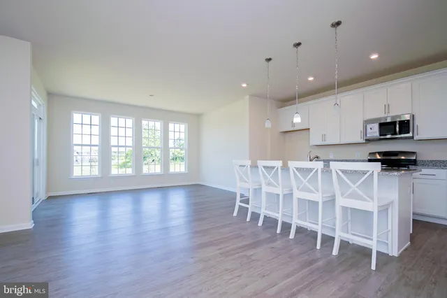 a view of a kitchen with furniture and wooden floor