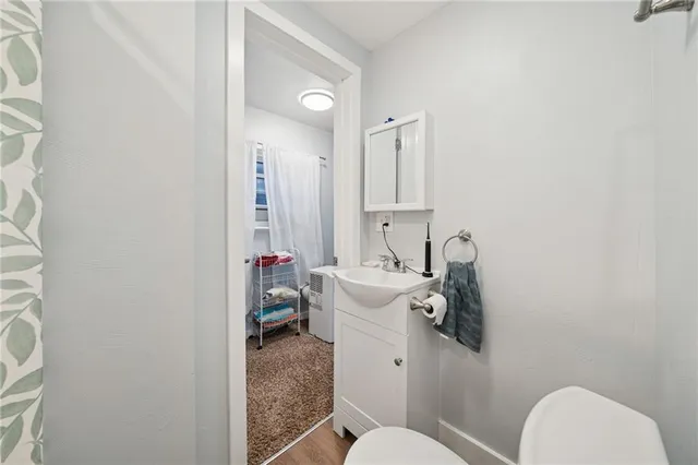 a bathroom with a toilet sink and mirror