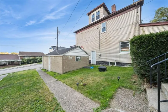 front view of house with a yard and trees