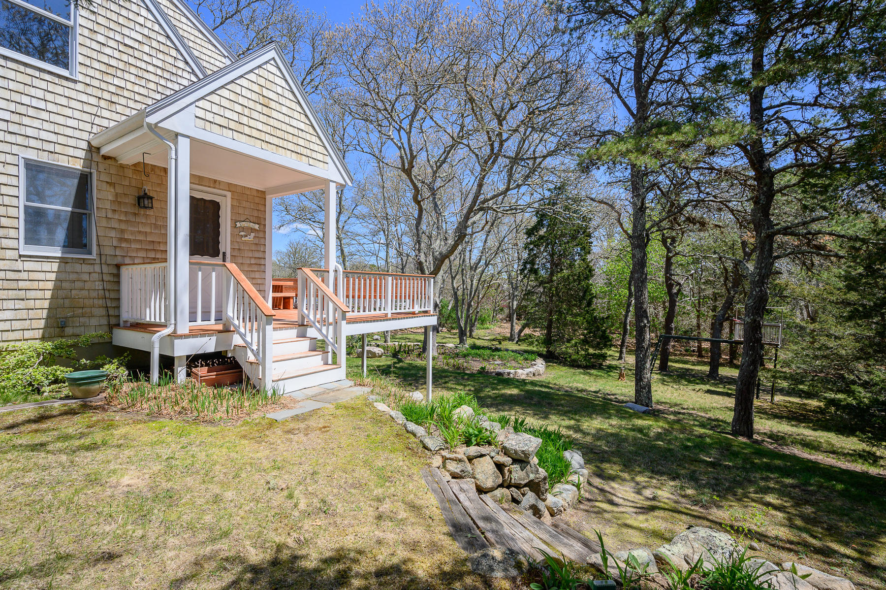 1221 County Road Cataumet, MA 02534 - Photo 3 of 42 a front view of a house with a yard table and chairs