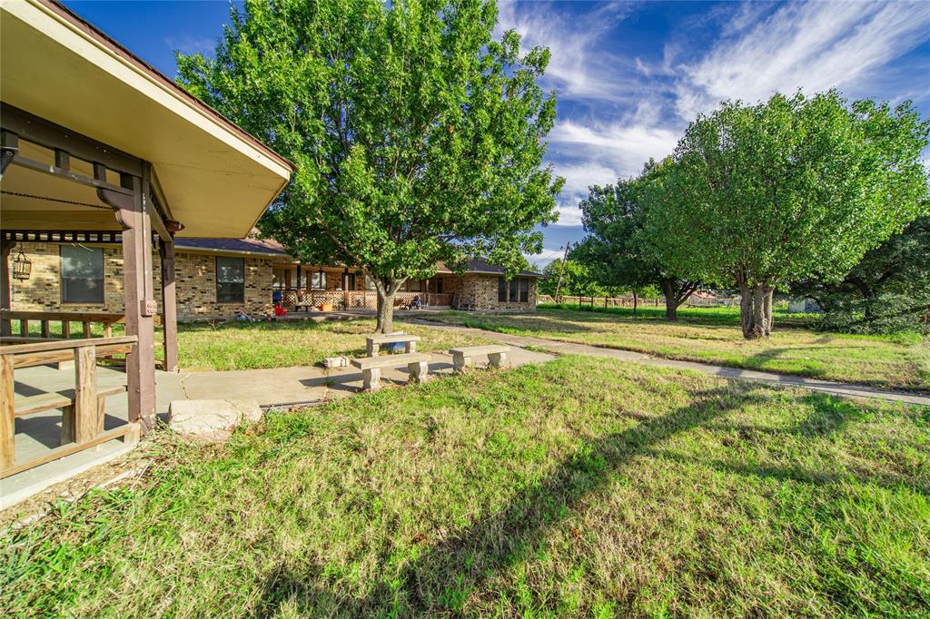 4320 Hickox Road Rowlett, TX 75089 - Photo 11 of 37 Expansive outdoor area featuring mature trees, a paved walkway, and a covered porch