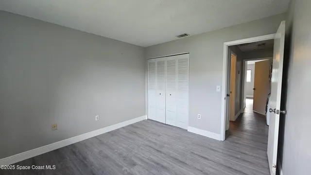 an empty room with wooden floor and closet