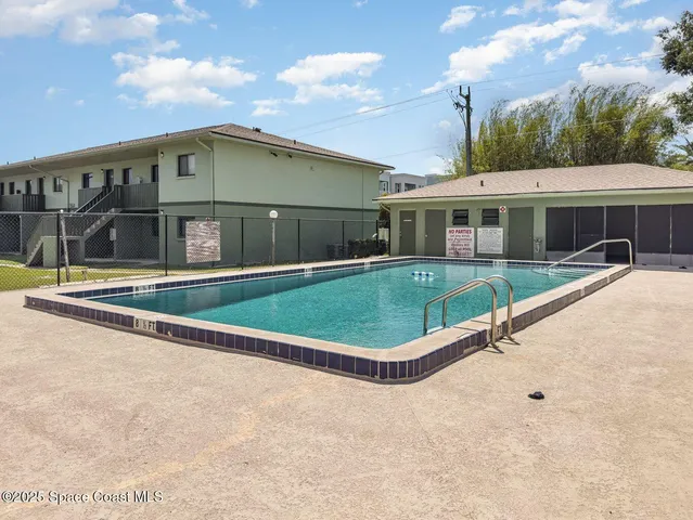an aerial view of residential houses with outdoor space and ocean view