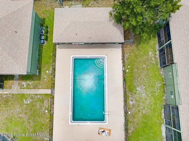 an aerial view of a house with a garden and swimming pool