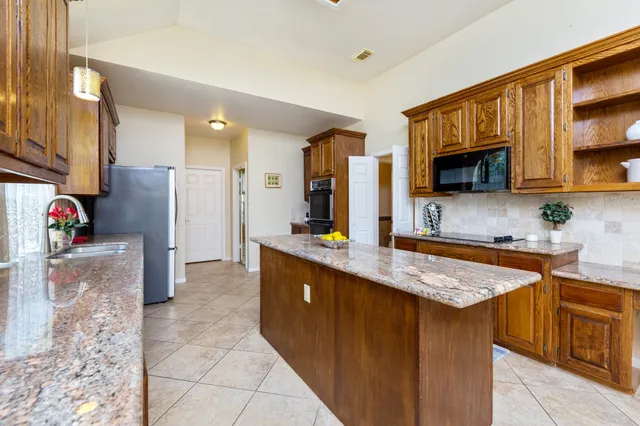 a kitchen with stainless steel appliances granite countertop a sink stove and refrigerator