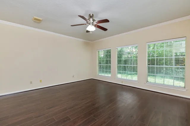 a view of wooden floor and a chandelier fan in a room