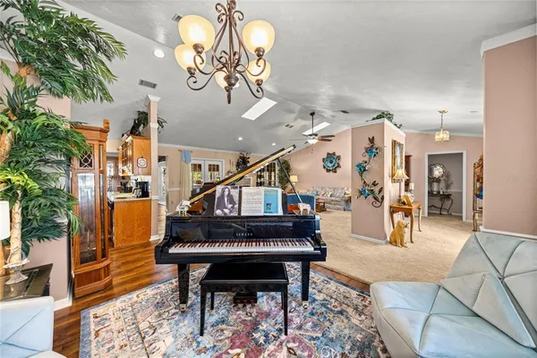 a dining room with wooden floor and a chandelier