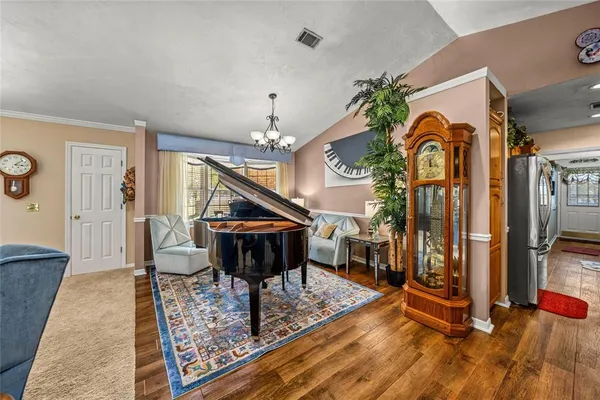 a kitchen with stainless steel appliances granite countertop a refrigerator a sink dishwasher a stove and a dining table with wooden floor