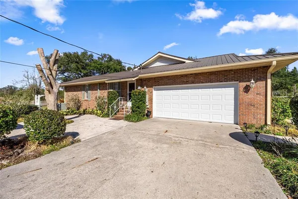 a view of a house with a yard balcony and a tree