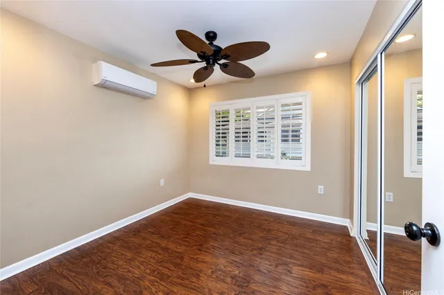 a view of a room with a ceiling fan and wooden floor