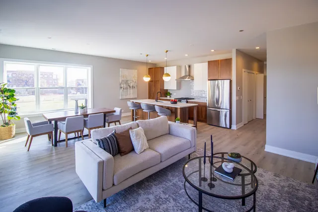 a living room with furniture a large window and a table