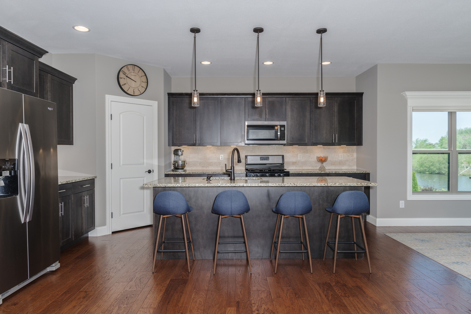 15924 Belfry Drive Bloomington, IL 61705 - Photo 21 of 59 a kitchen with stainless steel appliances granite countertop a table chairs refrigerator and microwave