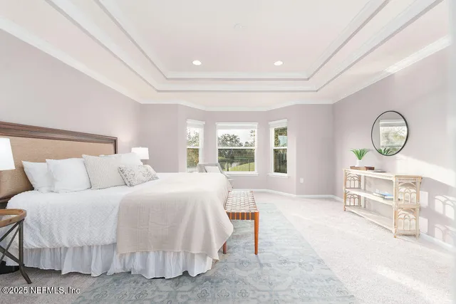 a spacious bedroom with a bed a mirror and a large window