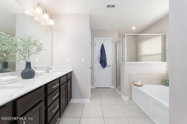 a spacious bathroom with a granite countertop sink a toilet a mirror and shower