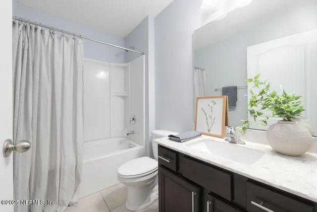 a bathroom with a granite countertop sink a toilet and shower