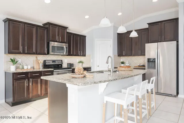 a kitchen with stainless steel appliances granite countertop a sink refrigerator and microwave