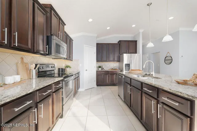a kitchen with stainless steel appliances granite countertop a sink a stove and a refrigerator