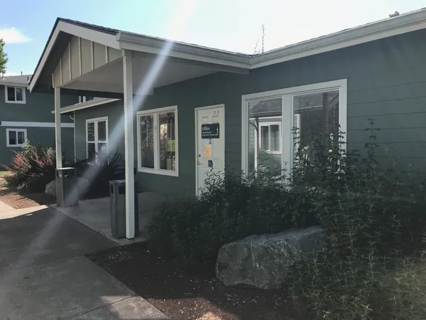 a view of a brick house next to a yard