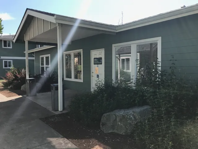 a view of a brick house next to a yard