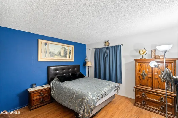 a bedroom with a bed and wooden floor