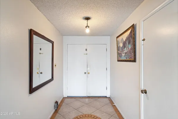 a view of a hallway with wooden floor and closet