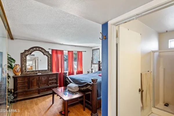 a bedroom with a bed a dresser and mirror