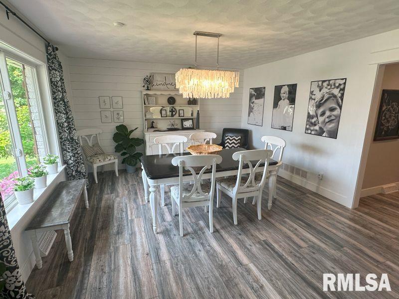 1144 Brookview Drive Dewitt, IA 52742 - Photo 12 of 28 a dining room with furniture a chandelier and wooden floor